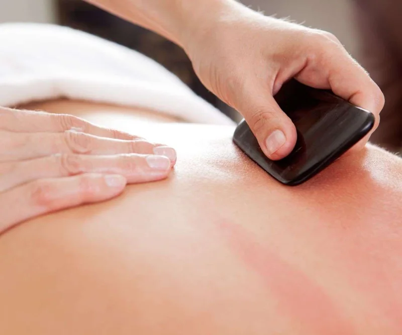 A smooth Gua-Sha tool used on the back